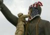 Un infante de marina estadounidense cubre el rostro de la estatua de Saddam Hussein en Bagdad días después de la invasión. La estatua luego fue derribada, convirtiéndose en una símbolo del derrocamiento del líder iraquí. GETTY