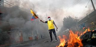 Un hombre sujetando una bandera de Ecuador protestando contra las políticas económicas del Gobierno de Guillermo Lasso en una calle de Quito. REUTERS/ADRIANO MACHADO