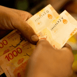 Billetes de 1000 pesos que se escurren cada vez más rápido de las manos de los argentinos. BBC